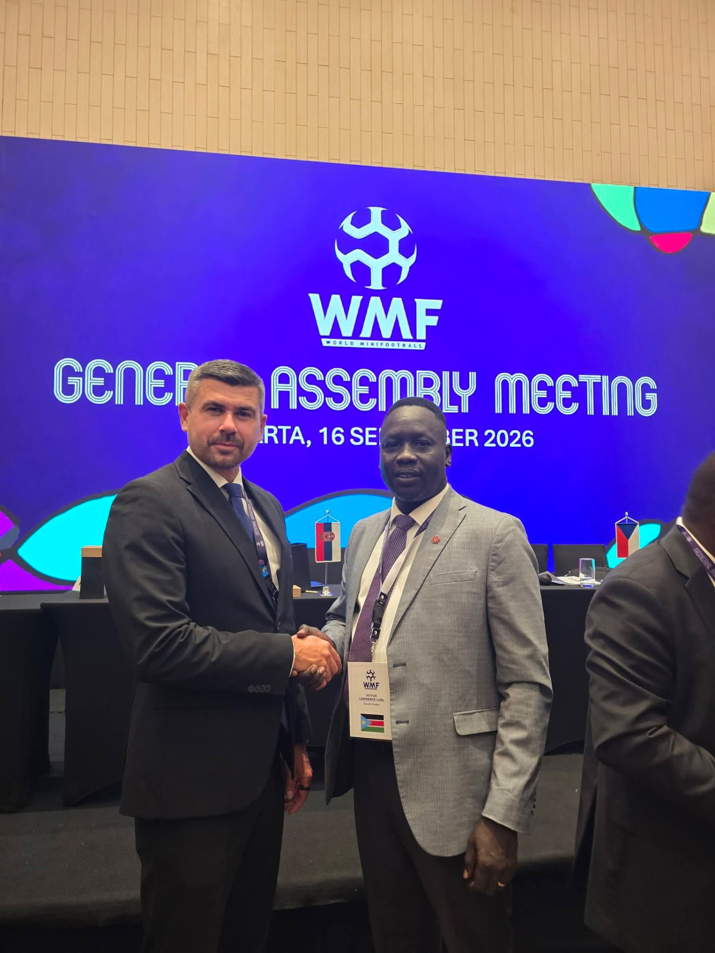 SSMF representative meeting a fellow delegate at the World Minifootball Federation General Assembly